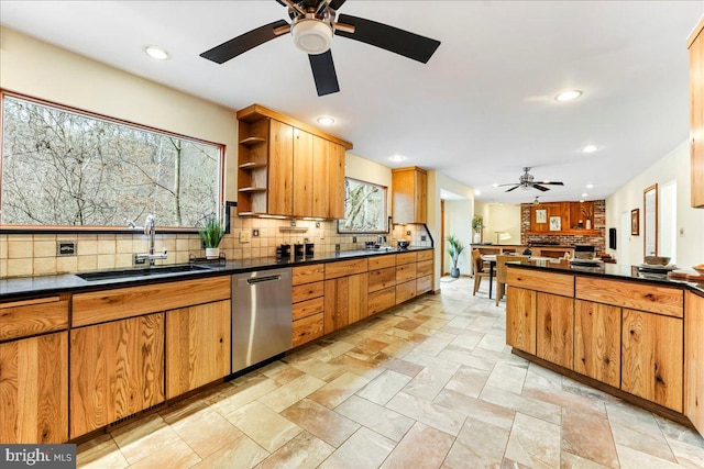 kitchen featuring decorative backsplash, dishwasher, dark countertops, a sink, and recessed lighting