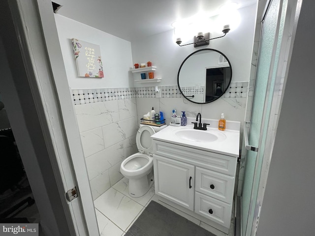 bathroom with tile walls, vanity, and toilet