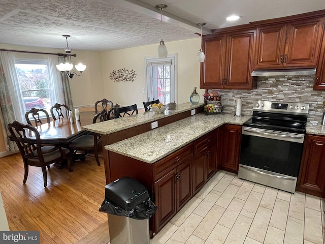 kitchen featuring light stone counters, decorative light fixtures, kitchen peninsula, and stainless steel range with electric cooktop