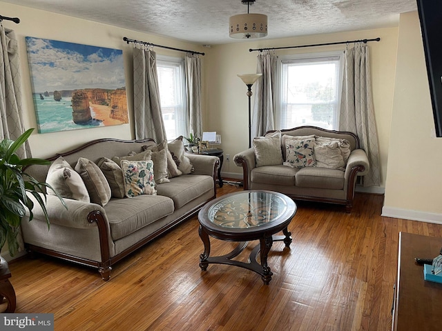 living room with wood-type flooring and a textured ceiling