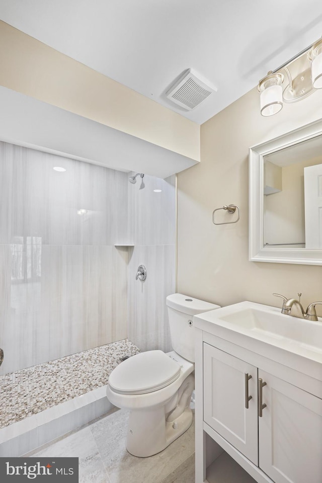 bathroom featuring vanity, toilet, and walk in shower