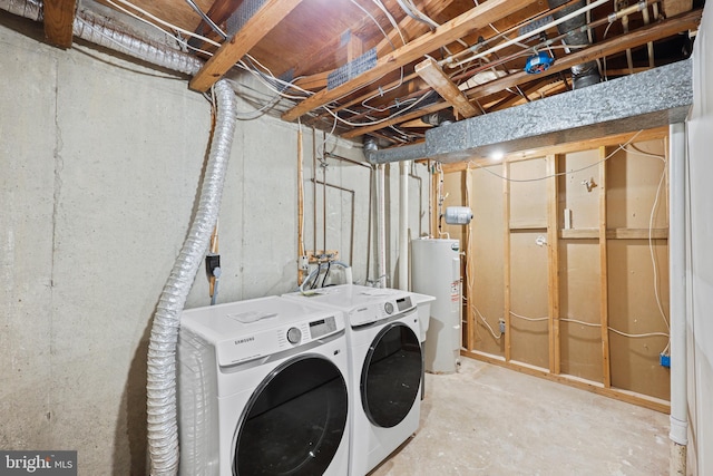 clothes washing area featuring washing machine and dryer and electric water heater