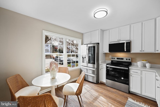 kitchen featuring white cabinetry, light wood-type flooring, and stainless steel appliances