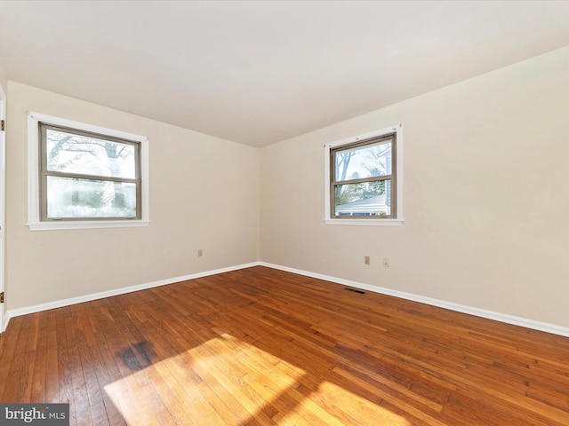 unfurnished room with hardwood / wood-style flooring