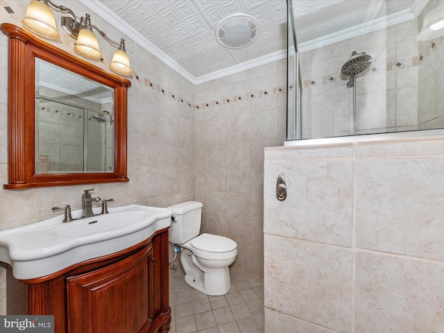 bathroom with tile walls, vanity, ornamental molding, toilet, and walk in shower