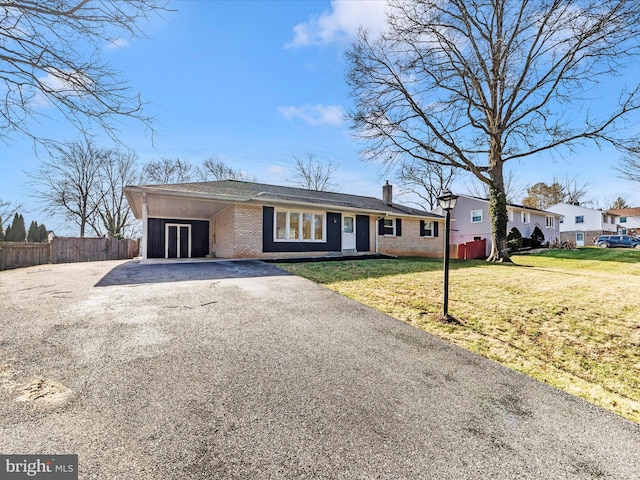 ranch-style home with a carport and a front yard