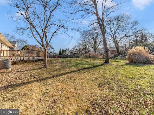 view of yard with a wooden deck and central air condition unit