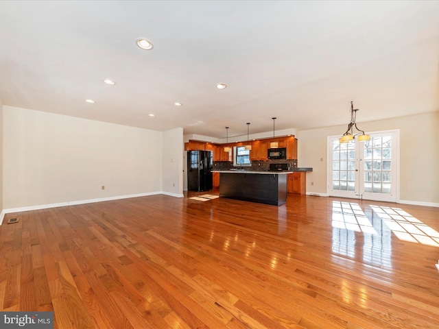 unfurnished living room with light hardwood / wood-style flooring and french doors