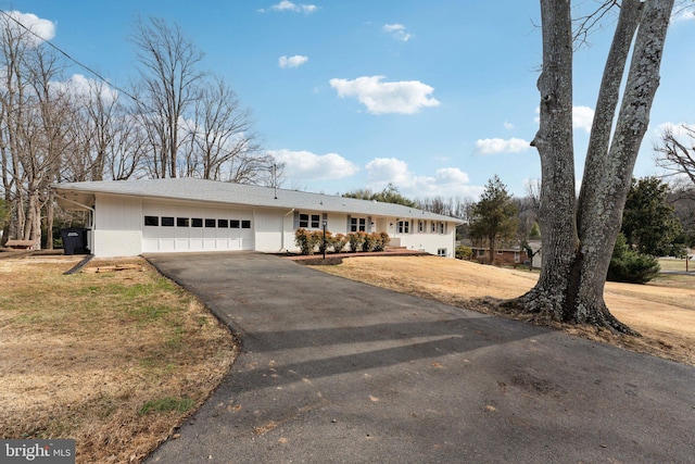 single story home featuring a garage and a front lawn