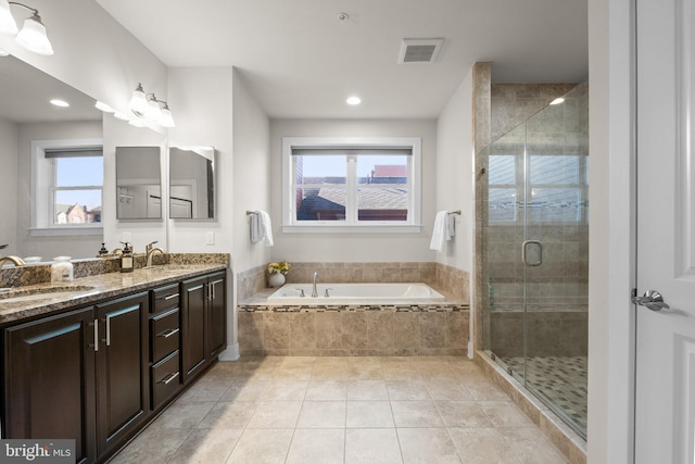 bathroom with a stall shower, plenty of natural light, a garden tub, and a sink