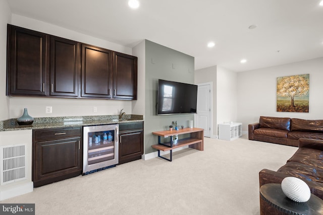 interior space with light carpet, beverage cooler, baseboards, indoor wet bar, and recessed lighting