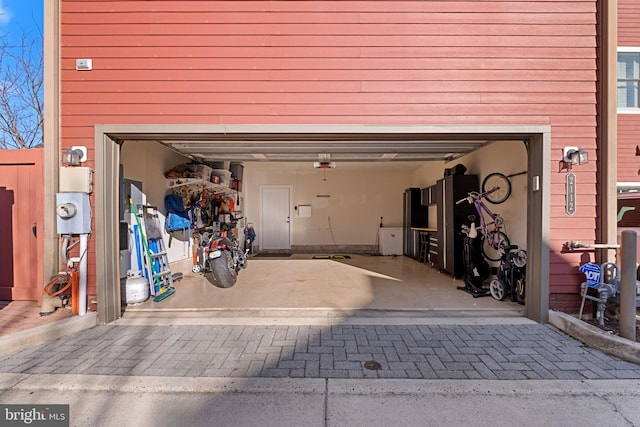 garage with decorative driveway and a garage door opener