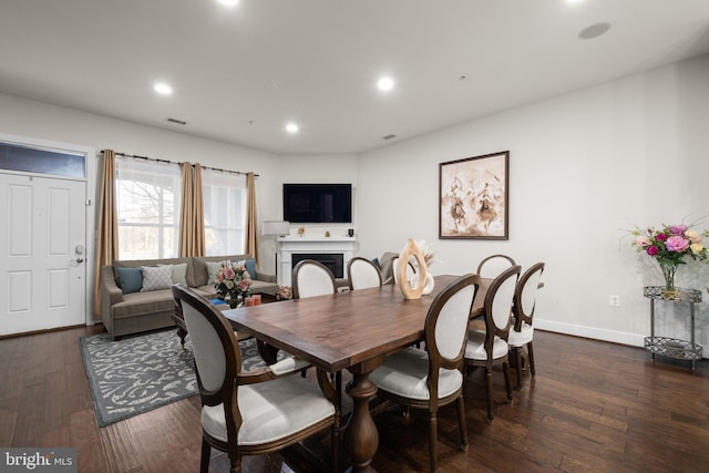 dining room with dark wood-type flooring, recessed lighting, visible vents, and a fireplace