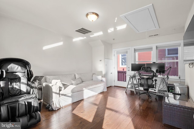 home office with attic access, visible vents, and wood finished floors