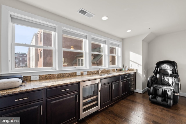 bar with plenty of natural light, beverage cooler, visible vents, dark wood-type flooring, and a sink