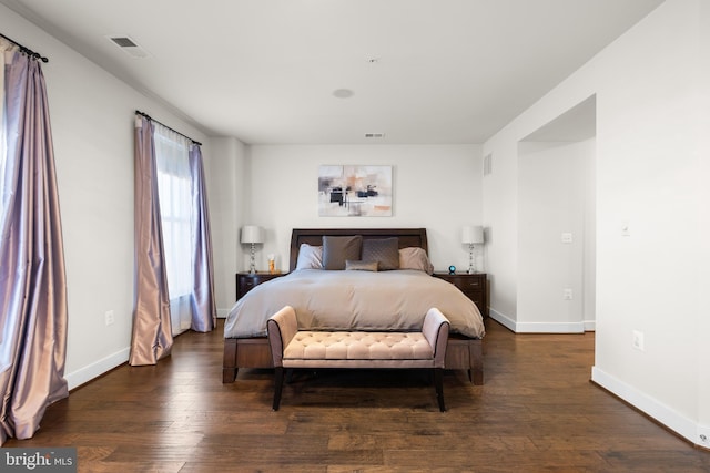 bedroom featuring visible vents, baseboards, and wood finished floors