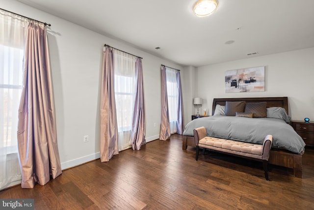 bedroom featuring baseboards, visible vents, and wood finished floors