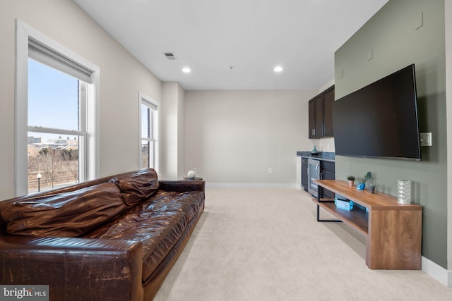 living room with recessed lighting, beverage cooler, light colored carpet, visible vents, and baseboards