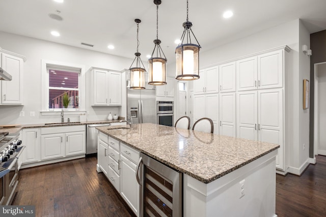 kitchen featuring stainless steel appliances, beverage cooler, white cabinetry, and a sink