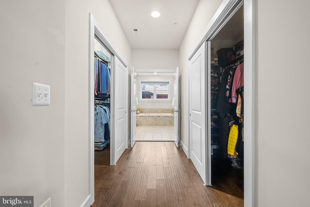 corridor featuring wood finished floors and visible vents