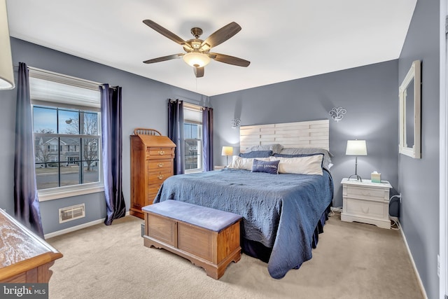 bedroom featuring baseboards, visible vents, a ceiling fan, and light colored carpet