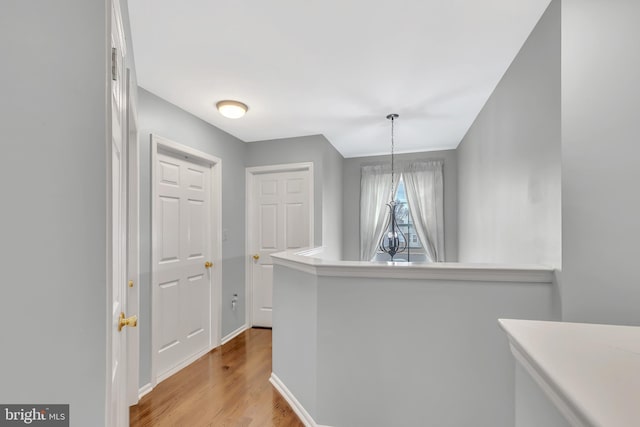 hallway featuring light wood-style floors and baseboards