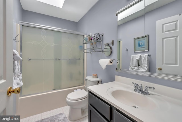 full bath featuring a skylight, vanity, toilet, and bath / shower combo with glass door