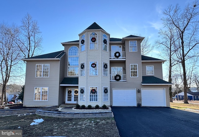 victorian house featuring driveway and an attached garage