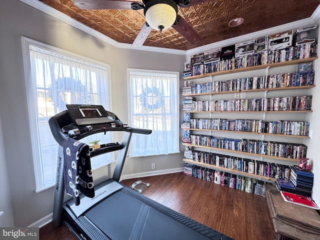 exercise area featuring ornamental molding, an ornate ceiling, and baseboards