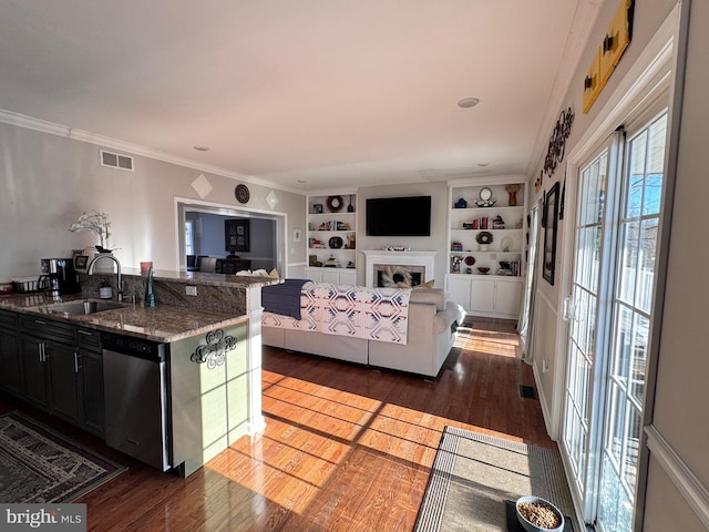 kitchen featuring dark wood finished floors, visible vents, stainless steel dishwasher, open floor plan, and a sink