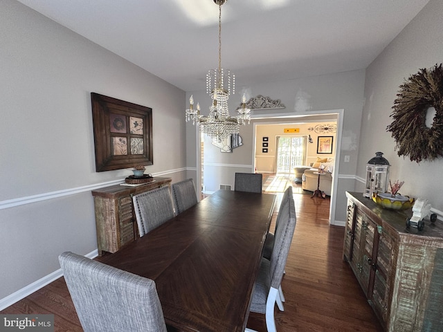 dining space featuring a notable chandelier, visible vents, baseboards, and dark wood-style flooring