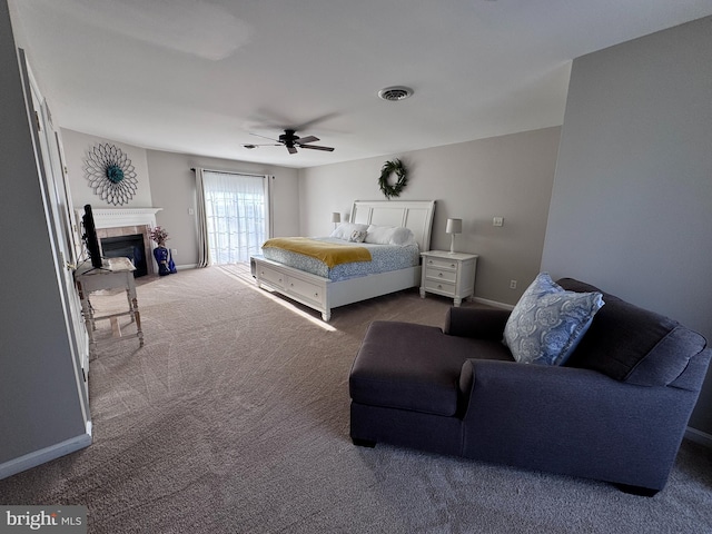 bedroom with a fireplace, dark colored carpet, visible vents, a ceiling fan, and baseboards