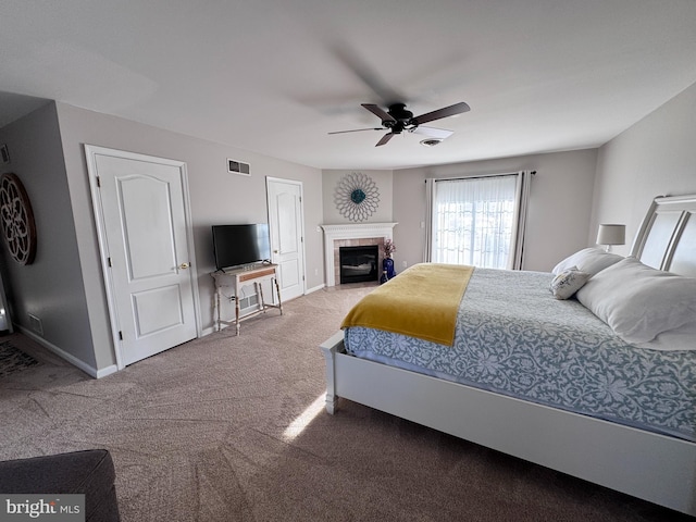 bedroom with ceiling fan, carpet floors, a fireplace, visible vents, and baseboards