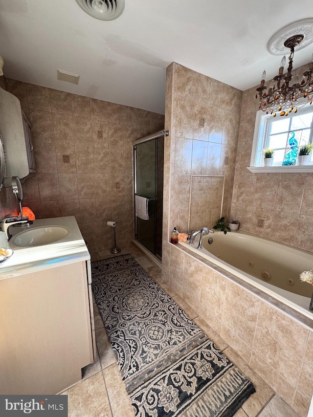 bathroom featuring a stall shower, tile patterned floors, a jetted tub, vanity, and tile walls