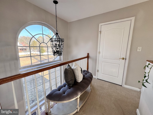 sitting room with baseboards, carpet, and an inviting chandelier