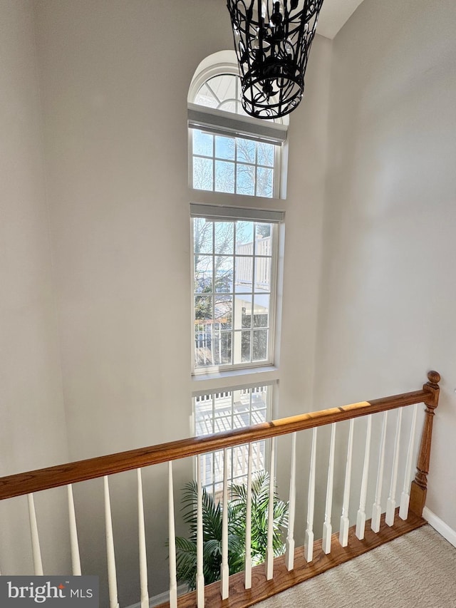 staircase with a high ceiling and baseboards