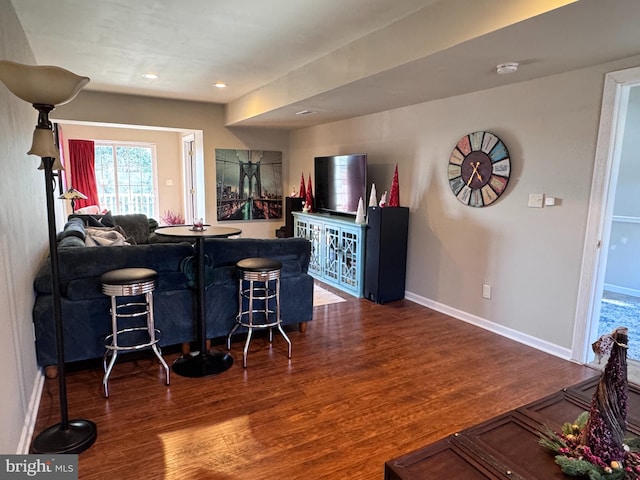 bar featuring dark wood-style floors, baseboards, bar area, and recessed lighting