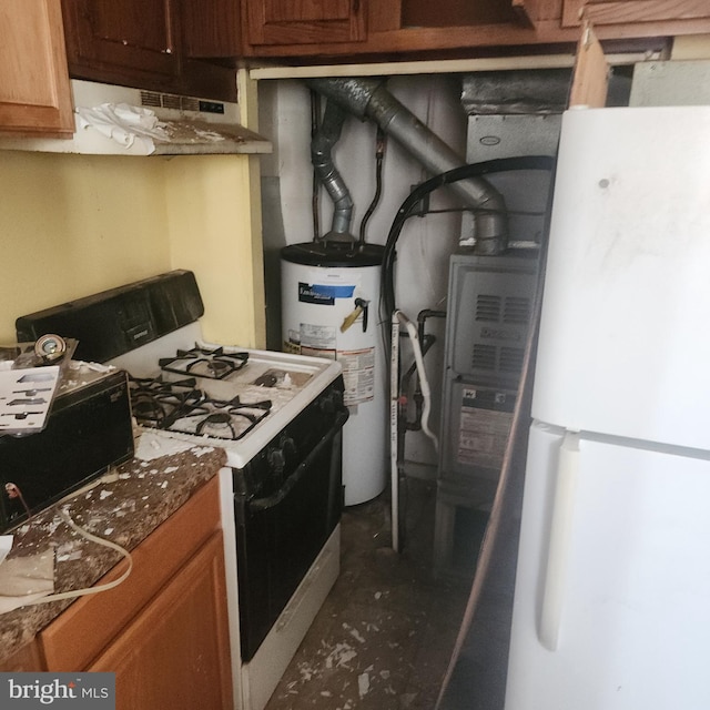 kitchen featuring water heater, gas range oven, and white fridge