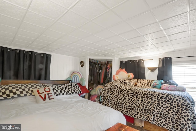 bedroom with a drop ceiling and a closet