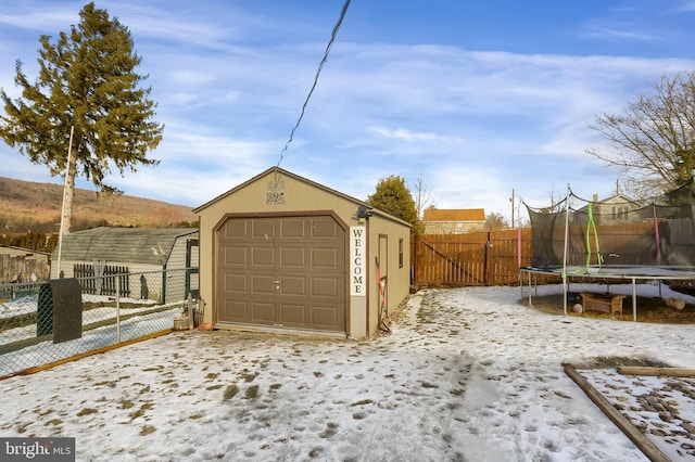 snow covered garage featuring a trampoline