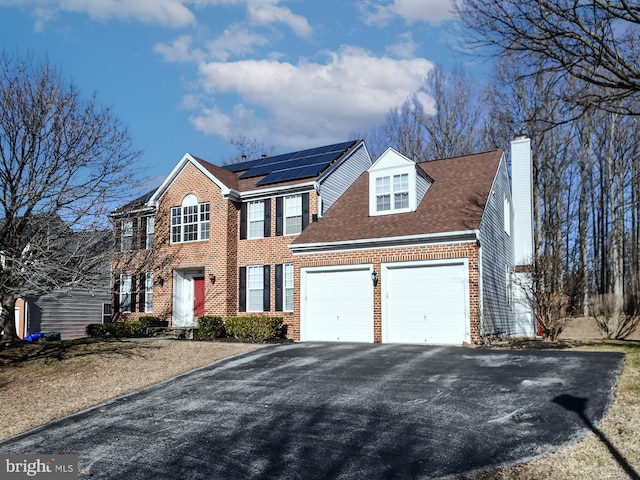 view of front of home with a garage and solar panels