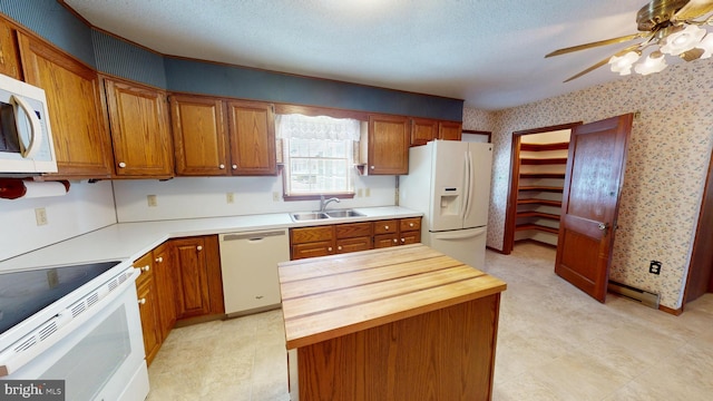 kitchen featuring sink, white appliances, ceiling fan, a textured ceiling, and wood counters