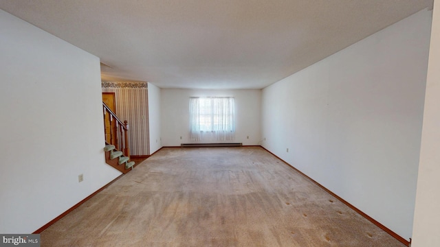 carpeted spare room with a baseboard radiator