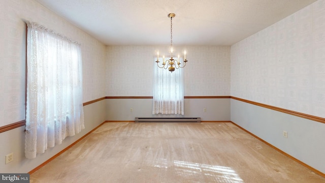 carpeted empty room featuring a baseboard heating unit and a chandelier