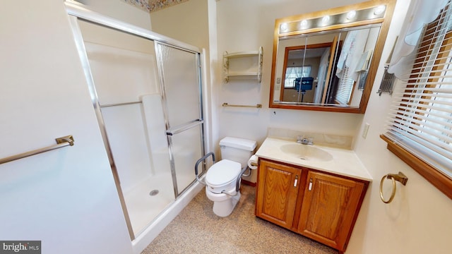 bathroom featuring vanity, toilet, and a shower with door