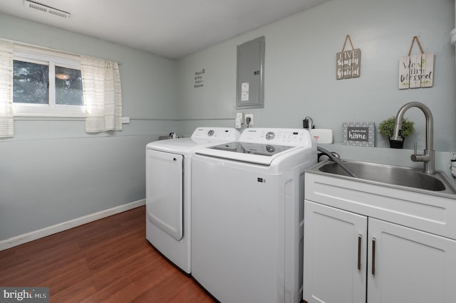 laundry room featuring washer and dryer, dark hardwood / wood-style floors, sink, cabinets, and electric panel