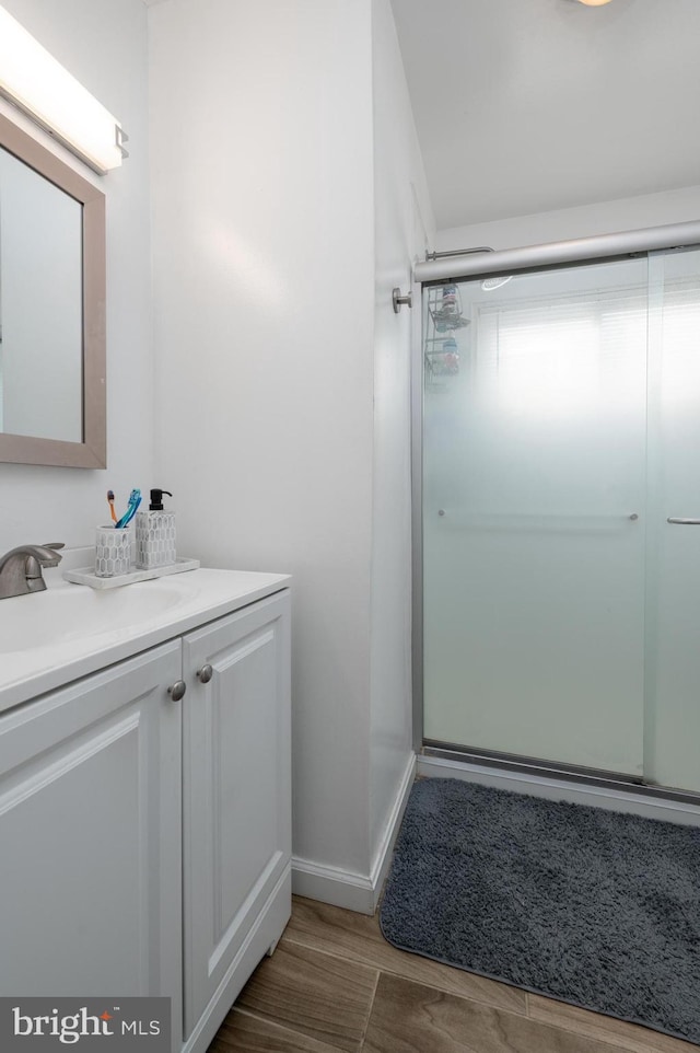 bathroom featuring vanity, an enclosed shower, and hardwood / wood-style flooring