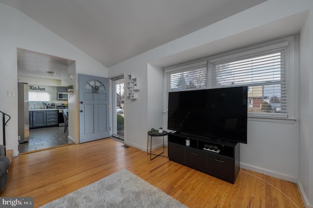 living room featuring vaulted ceiling and light wood-type flooring