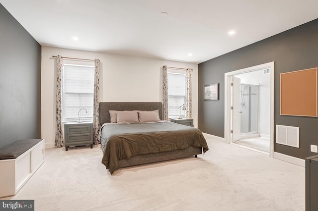 carpeted bedroom with ensuite bath and multiple windows