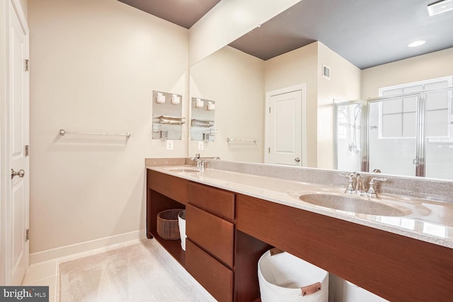 bathroom featuring tile patterned flooring, vanity, and a shower with shower door